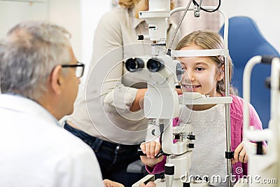 Mature doctor look with eye apparatus in childâ€™s eye Stock Photo