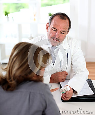 Mature doctor prescribing medication to patient Stock Photo