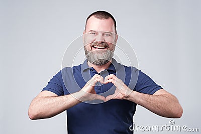 Mature european man with beard making out of the hands heart. Stock Photo
