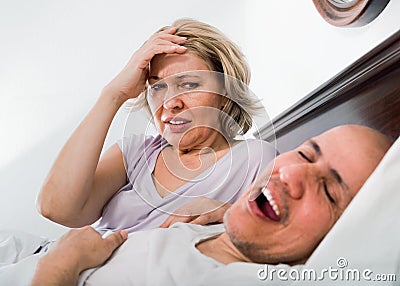 Mature evil woman disturbed with partner snores Stock Photo