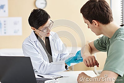 Mature female doctor inspecting patient with skin rash Stock Photo