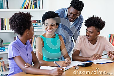 Mature female teacher with african american students Stock Photo