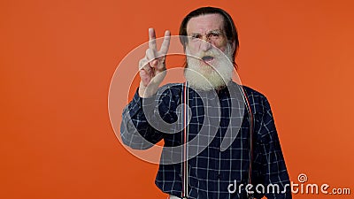Mature grandfather showing victory sign, hoping for success and win, doing peace gesture, smiling Stock Photo