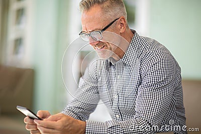 Mature handome man sitting outside reading his emails. Stock Photo
