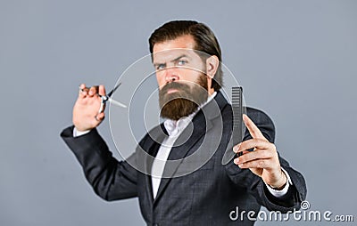 Mature and handsome. hairdresser makes hairstyle. Fashion portrait of hipster. handsome man with long dark haired beard Stock Photo
