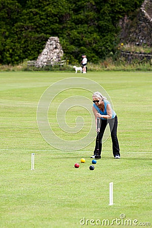 Mature lady playing croquet in a rural setting in Northumbria, England Editorial Stock Photo