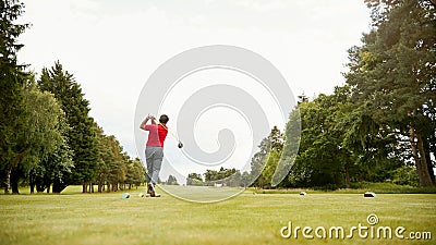 Mature Male Golfer Hitting Tee Shot Along Fairway With Driver Stock Photo