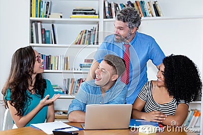 Mature male professor teaching group of multi ethnic college students Stock Photo