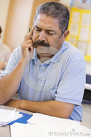 Mature male student frowning in class Stock Photo