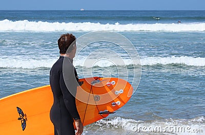 Mature male surfer looks at waves Editorial Stock Photo