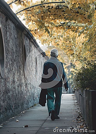 Mature man casually walking down a city sidewalk Stock Photo