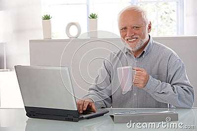 Mature man with computer smiling Stock Photo