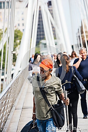Mature man crossing the Hungerford Bridge in London Editorial Stock Photo