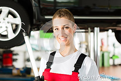 Mature man and female car mechanic in workshop Stock Photo