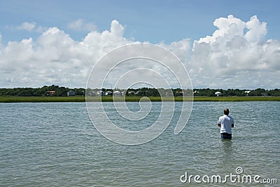 Mature man fishing alone in bay Stock Photo