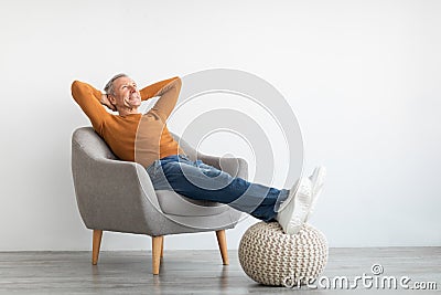 Mature man having rest at home on the chair Stock Photo