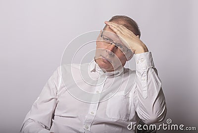 MAture man holds his hands on head in despair, trouble, problem Stock Photo