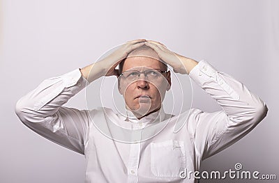 MAture man holds his hands on head in despair, trouble, problem Stock Photo