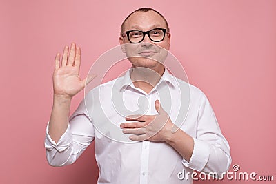 Mature man keeping hand on chest making promise, swearing to tell the truth Stock Photo