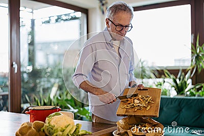 Mature man making compost from leftovers Stock Photo