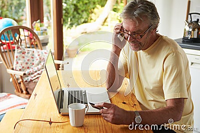 Mature Man Making On Line Purchase Using Credit Card Stock Photo