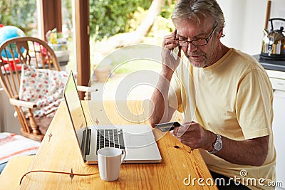 Mature Man Making On Line Purchase Using Credit Card Stock Photo