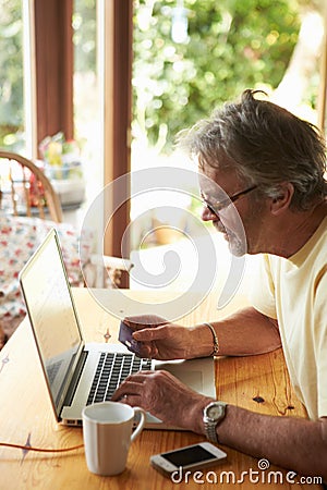 Mature Man Making On Line Purchase Using Credit Card Stock Photo