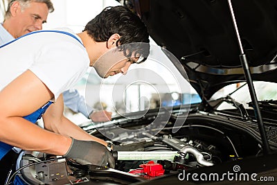 Mature man and mechanic looking at car engine Stock Photo