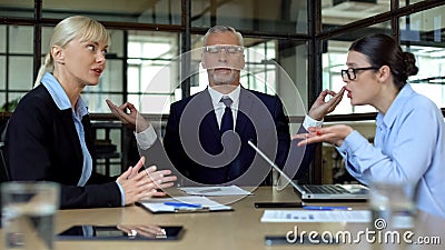 Mature man meditating in office tired of shouting colleagues, reducing stress Stock Photo