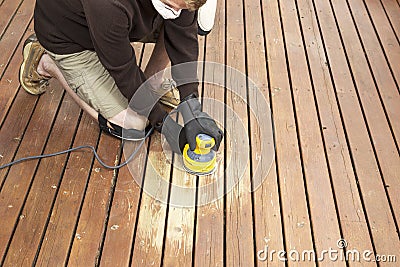 Mature man performing maintenance on home wooden deck Stock Photo