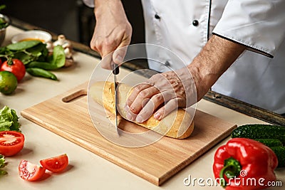 Mature man professional chef cooking meal indoors Stock Photo