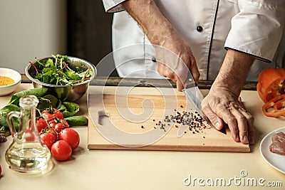 Mature man professional chef cooking meal indoors Stock Photo