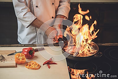 Mature man professional chef cooking meal indoors Stock Photo