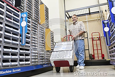 Mature man pushing handtruck in hardware store Stock Photo