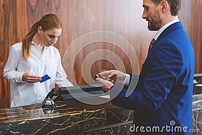 Mature man standing at check-in desk Stock Photo