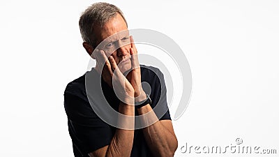 Mature man stressed, hands held to his face with worry Stock Photo