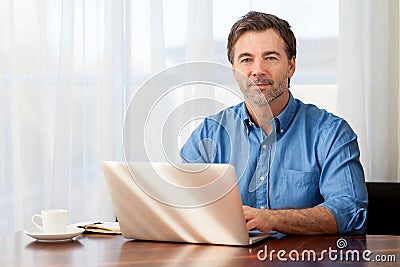 Mature man working at home in the kitchen Stock Photo