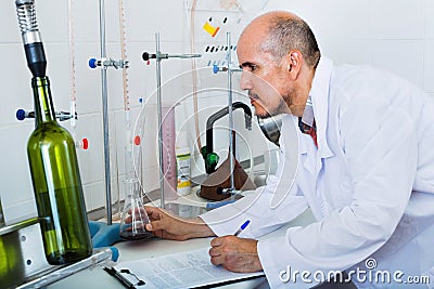 Mature man working on quality of products in winery lab Stock Photo