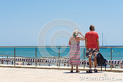 Mature married couple on the waterfront in the Sitges, Barcelona, Catalunya, Spain. Copy space for text. Editorial Stock Photo