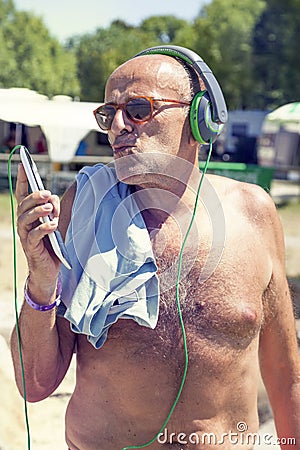 Mature modern man listens to music with headphones Stock Photo