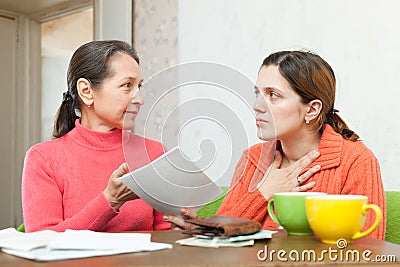 Mature mother berates daughter for bills Stock Photo