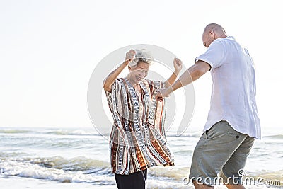 Mature mother and son dancing on the beach Stock Photo