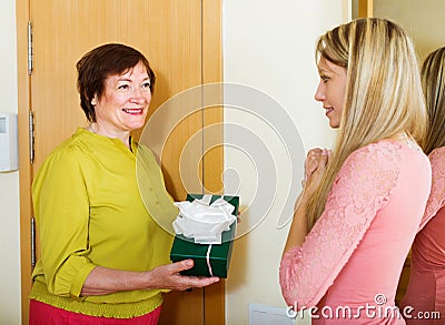 Mature neighbor presenting gift to young girl Stock Photo