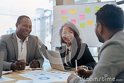 Mature older businesswoman negotiating growth business plan with diverse executive managers at boardroom Stock Photo