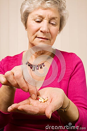 Mature older woman taking a tablet or pill Stock Photo