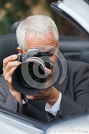 Mature paparazzi taking picture with professional camera Stock Photo