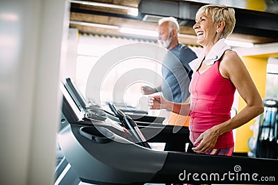 Senior people running in machine treadmill at fitness gym club Stock Photo