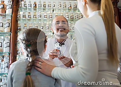 Mature pharmacist consulting customers Stock Photo