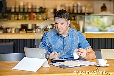 Mature small business owner calculating finance bills of activity, Entrepreneur using laptop and calculator to work Stock Photo