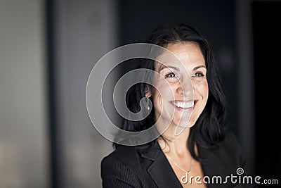 Mature Spanish Businesswoman Smiling And looking Away. At Home Stock Photo